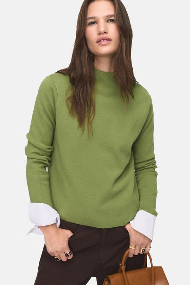 Groene trui met ronde hals van MANGO, met lange mouwen, gedragen met een wijde bruine broek.