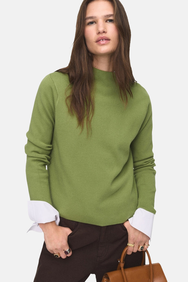 Groene trui met ronde hals van MANGO, met lange mouwen, gedragen met een wijde bruine broek.