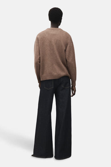 Pull à col rond marron de MANGO, porté avec un jean ample taille haute, vue arrière.
