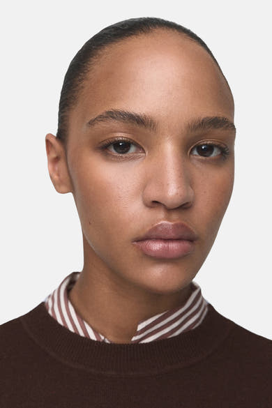 Pull à col rond multicolore de MANGO, porté sur une chemise rayée à col, en maille lisse.
