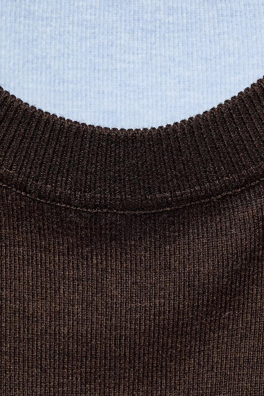 Pull à col rond marron de MANGO, en maille côtelée avec col bleu clair visible.