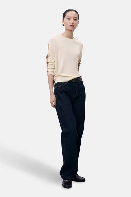 Beige ronde hals trui van MANGO met bruine strepen op de mouwen, gedragen met een donkerblauwe jeans en een bruine riem.