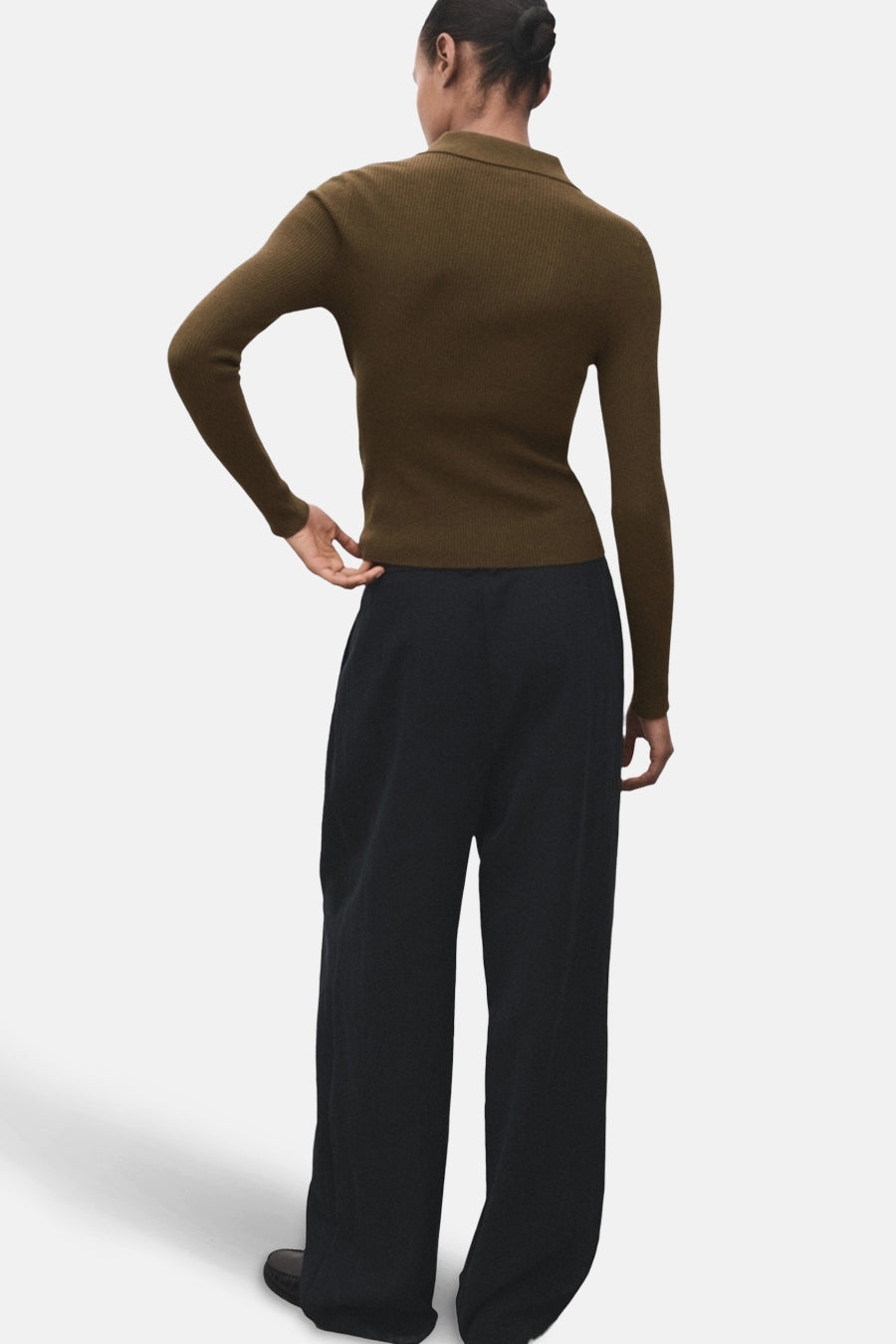 Pull à col rond kaki de MANGO, coupe ajustée, manches longues et pantalon noir ample.