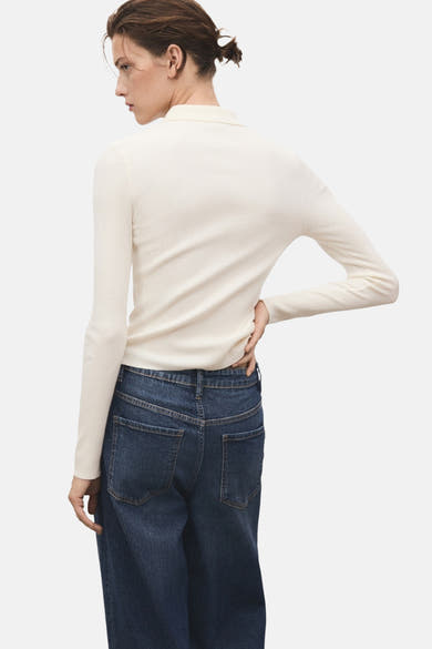 Pull à col rond beige de MANGO, en tricot côtelé, porté avec un jean bleu.