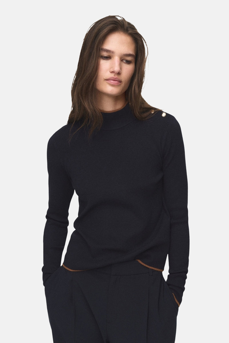 Pull à col rond bleu de MANGO, avec boutons dorés décoratifs sur l'épaule et finitions marron contrastantes.