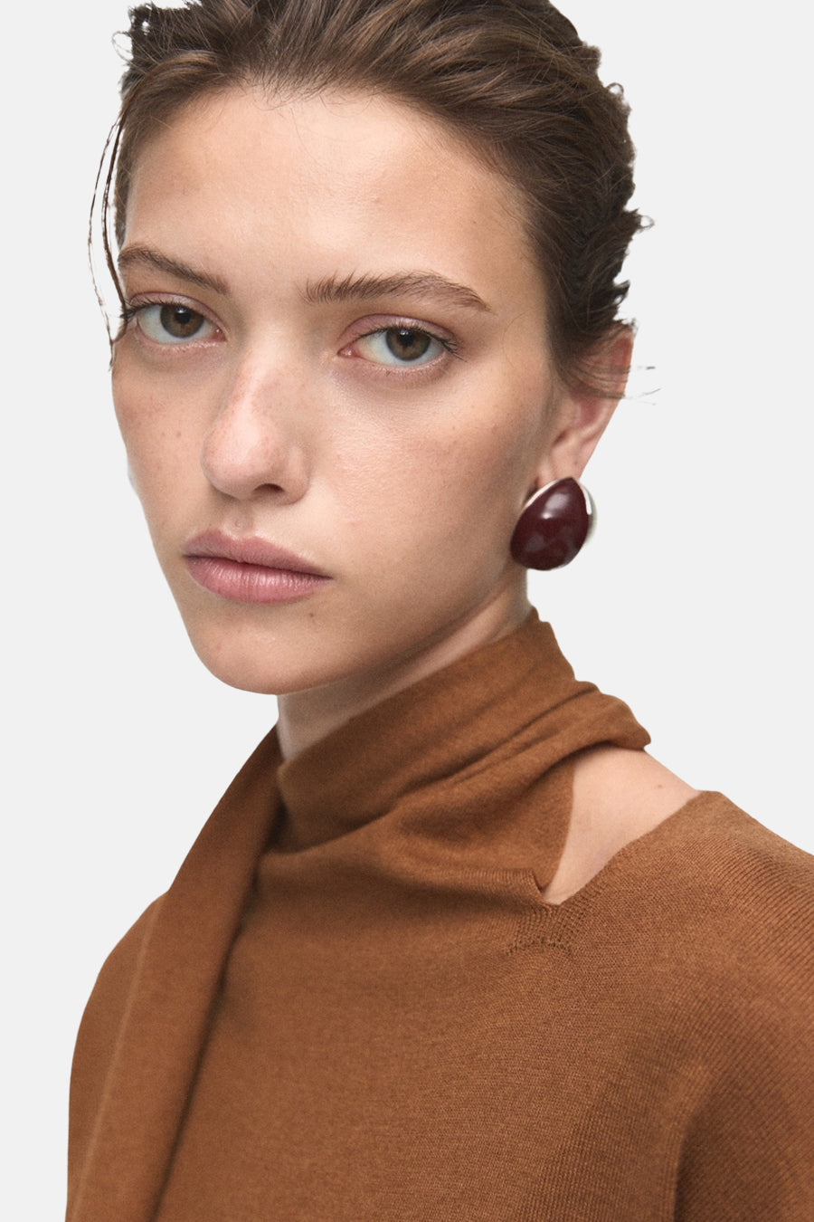 Pull à col rond brun de MANGO, avec un col montant et une épaule dénudée, porté par un mannequin.
