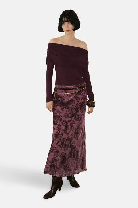 Bordeaux rondehals trui van MANGO, off-shoulder stijl, gedragen met een lange rok met bloemenprint en een kettingriem.
