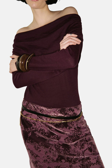 Bordeaux ronde hals trui van MANGO met houten armbanden en een rok met bloemenprint.