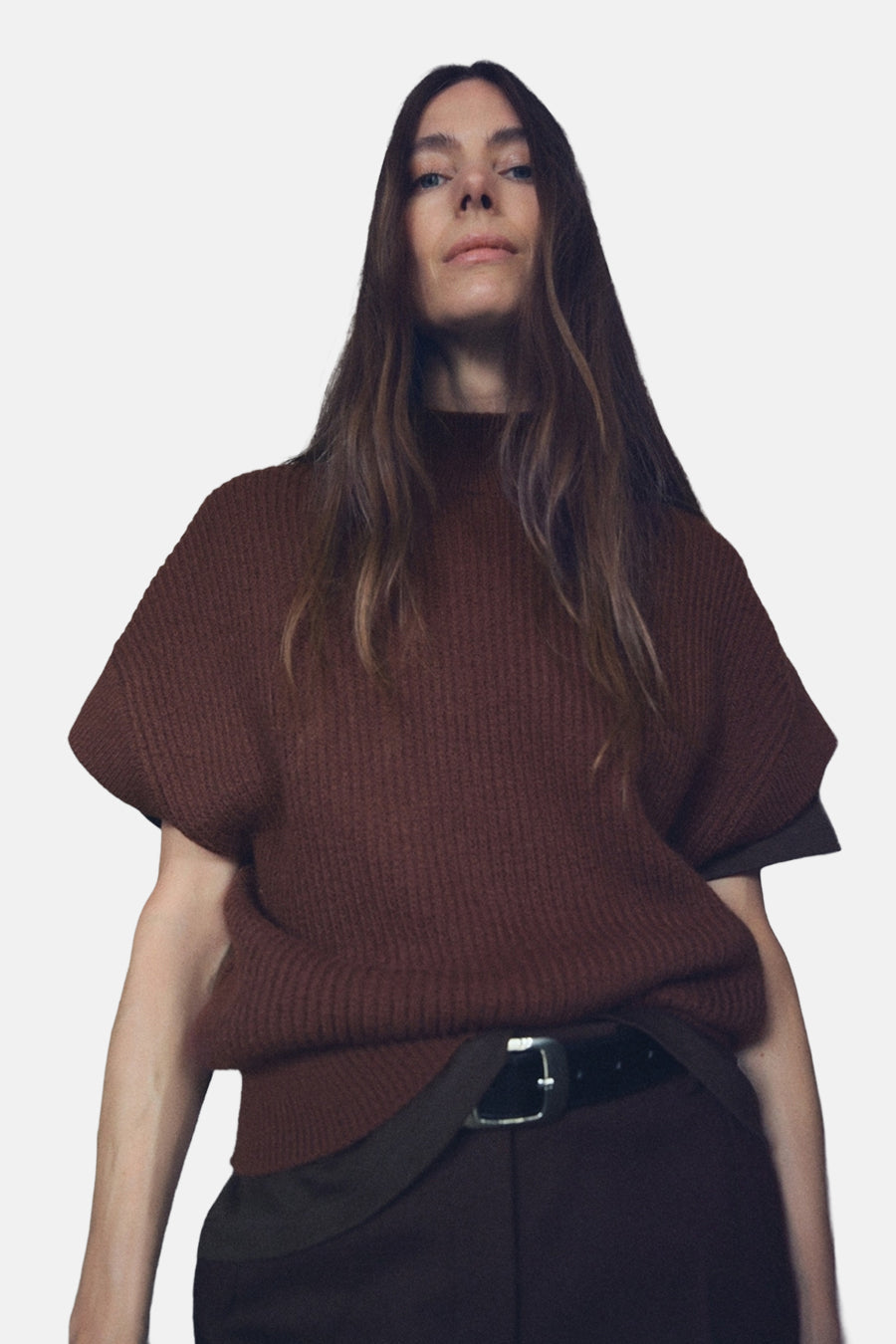 Débardeur marron de MANGO, porté avec une ceinture noire sur un pantalon marron.