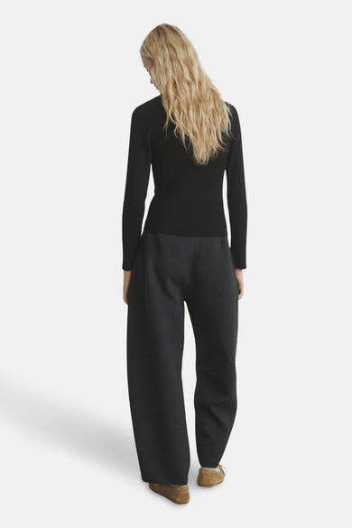 Pull à col rond noir de MANGO, avec des manches longues et une texture côtelée.
