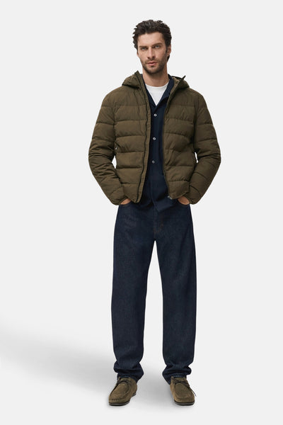 Veste courte kaki by MANGO, portée avec une chemise bleu marine, un t-shirt blanc et un jean ample bleu foncé.