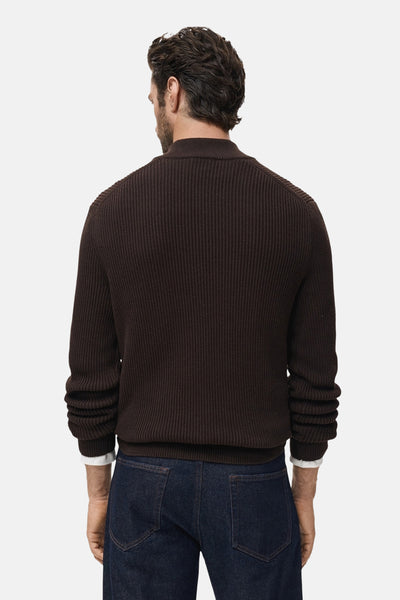 Bruine coltrui van MANGO, in ribgebreid, gedragen met een donkerblauwe jeans.