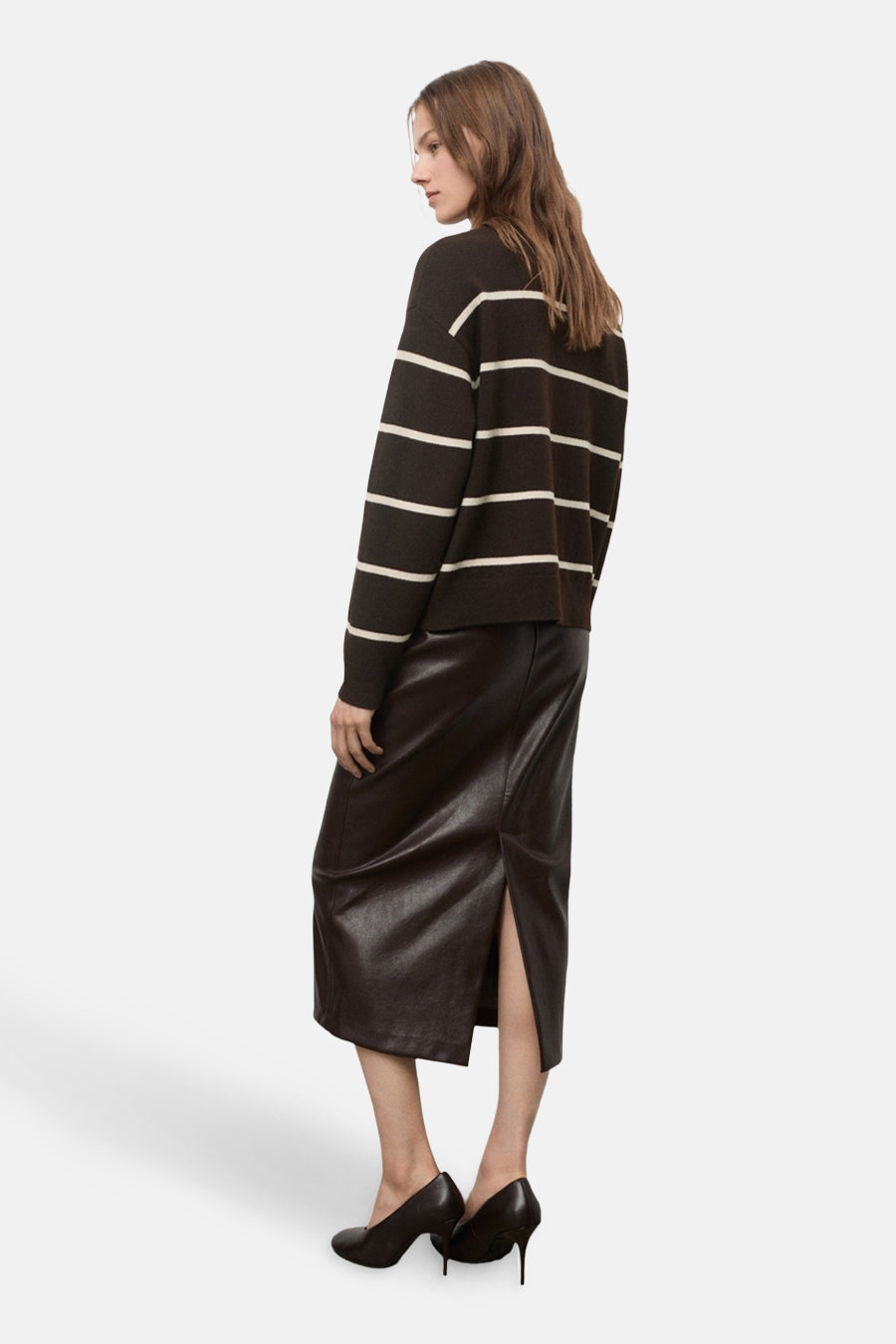 Pull à col rond marron rayé blanc de MANGO, porté avec une jupe crayon en cuir marron et des escarpins.