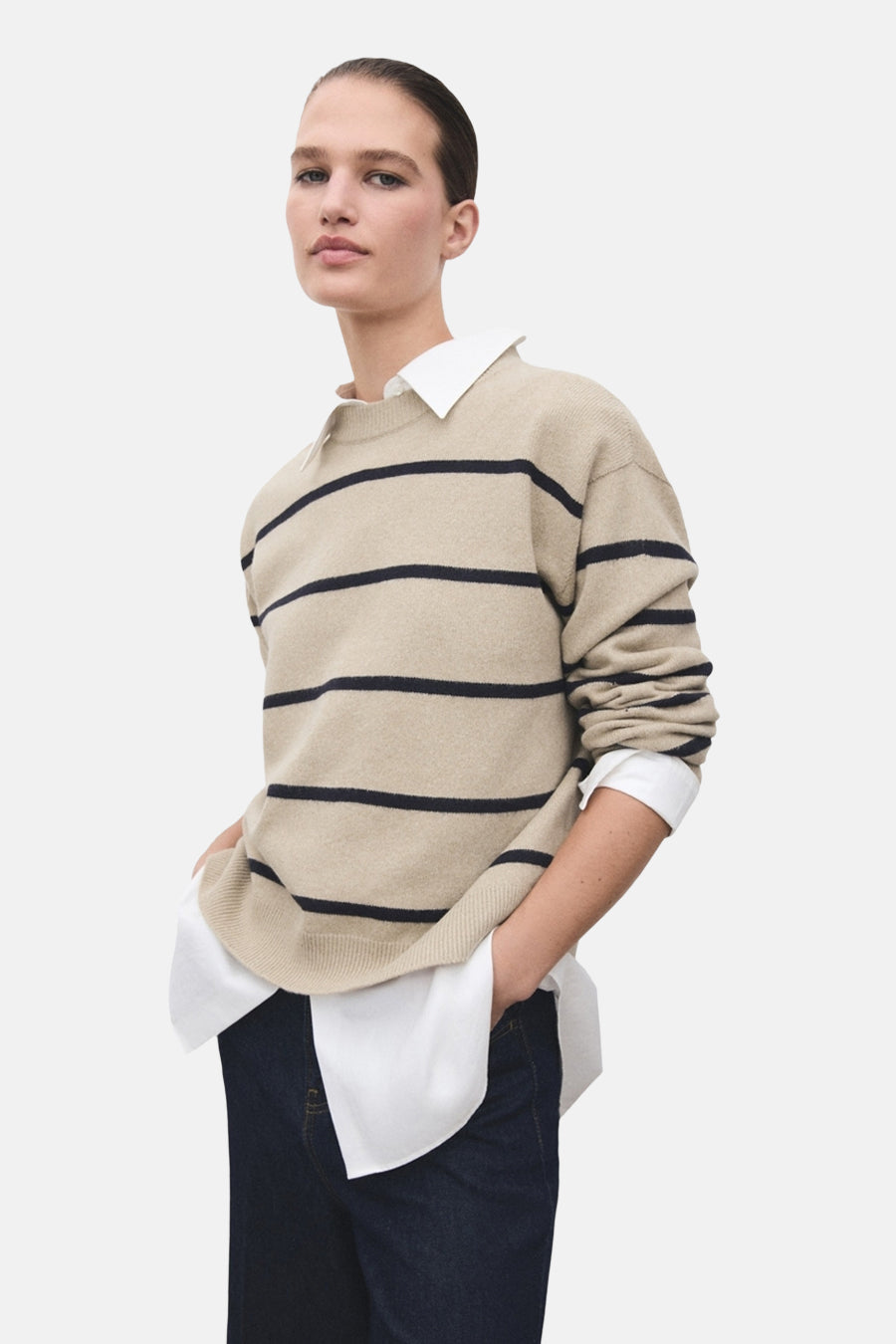 Beige ronde hals trui met strepen van MANGO, gedragen met een korte spijkerbroek en zwarte laarzen.
