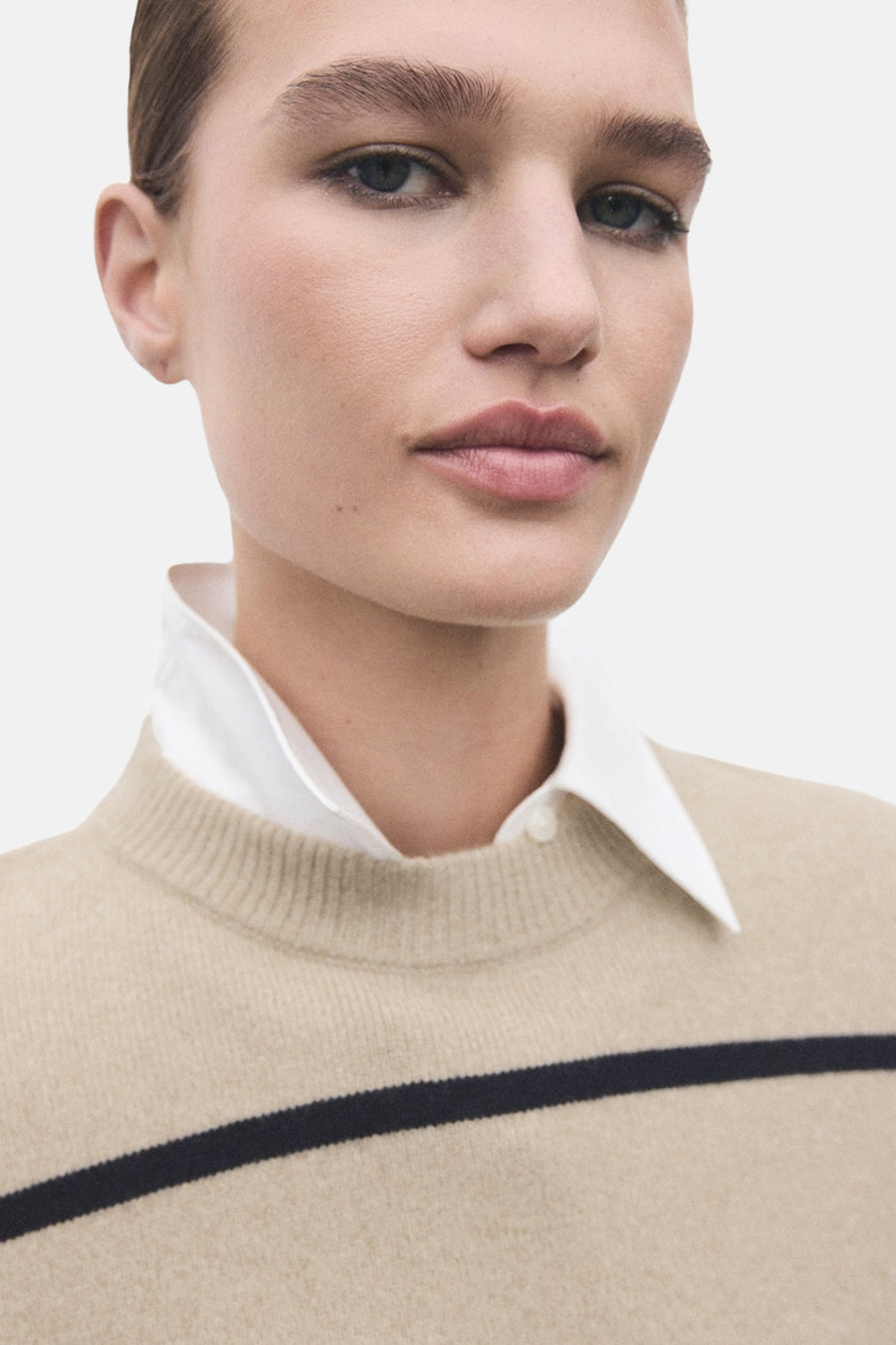 Beige trui met ronde hals van MANGO, gedragen met een wit overhemd met kraag.