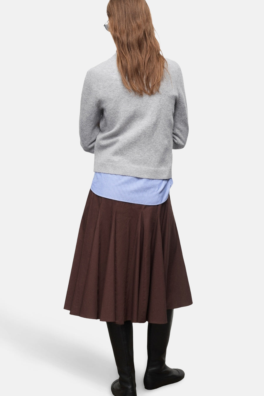 Pull à col rond gris de MANGO, porté avec une chemise rayée et une jupe marron, vue de dos.
