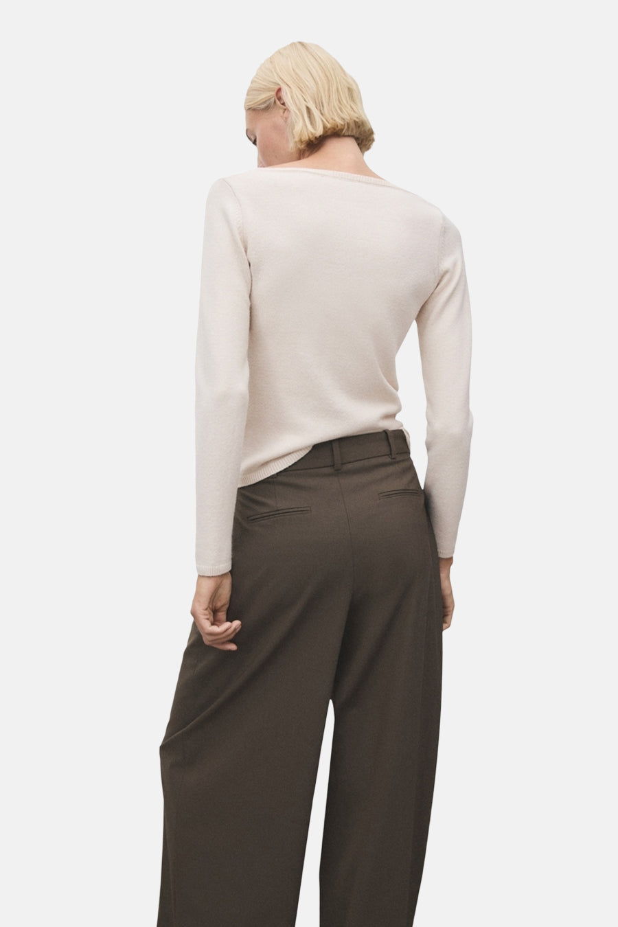 Pull à col rond écru de MANGO, porté avec un pantalon ample marron, vue de dos.
