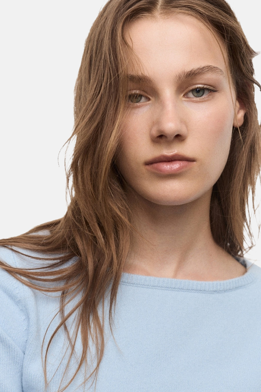 Pull bleu à col rond de MANGO, porté par un mannequin aux cheveux châtains.
