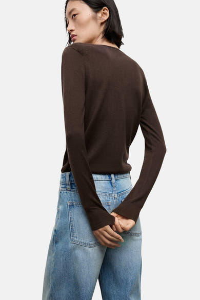 Pull à col rond brun de MANGO, porté avec un jean taille haute bleu clair, vue de dos.
