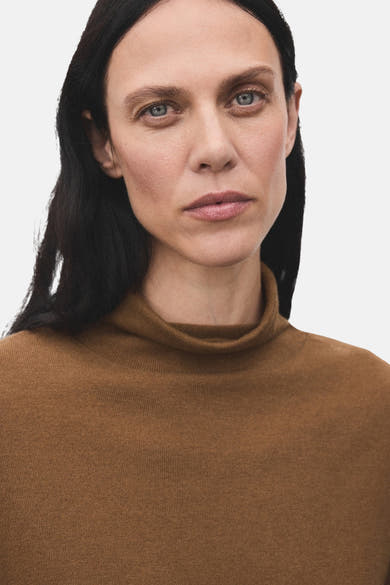 Pull à col roulé brun de MANGO, porté par un mannequin aux cheveux noirs.