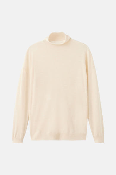 Pull à col roulé écru de MANGO, en maille fine, sur fond blanc.