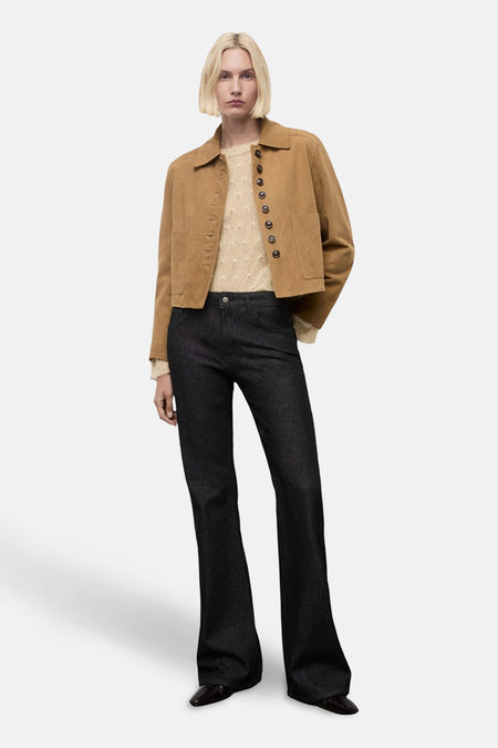 Beige ronde hals trui van MANGO, gedragen met een korte bruine jas en een zwarte wijde broek.