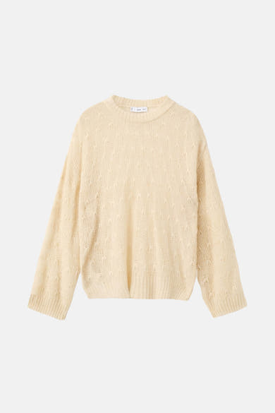 Pull à col rond beige de MANGO, avec une texture tricotée et un motif ajouré délicat.
