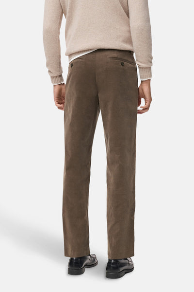Pantalon de saison brun de MANGO, texture côtelée, porté avec un pull beige et des mocassins noirs.