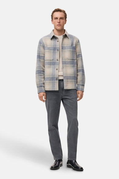Veste courte multicolore de MANGO, avec motif à carreaux et portée sur un pull et un jean gris.