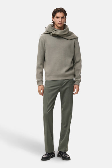 Sweat gris col O de MANGO, porté avec un pantalon olive et des mocassins noirs.