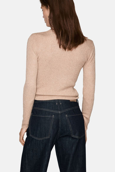 Pull à col roulé beige de MANGO, porté avec un jean indigo, vu de dos.