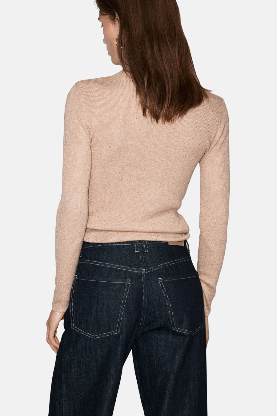 Pull à col roulé beige de MANGO, porté avec un jean indigo, vu de dos.