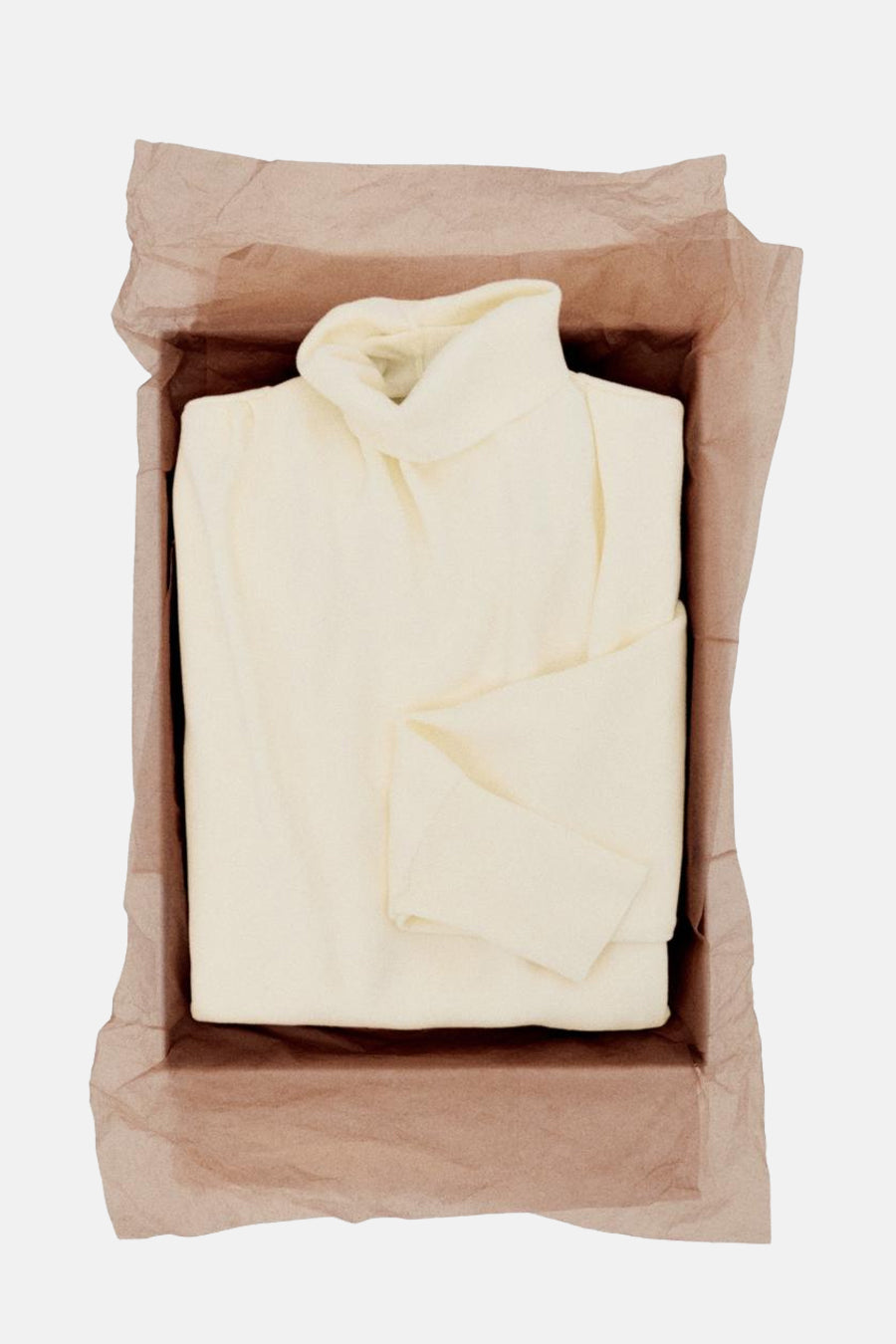 Pull à col roulé écru de MANGO, présenté dans une boîte avec du papier de soie.