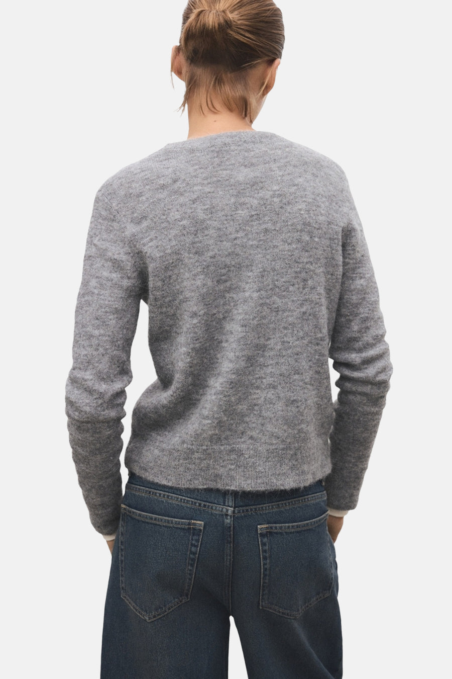 Pull à col rond gris de MANGO, porté avec un jean bleu foncé, vue de dos.
