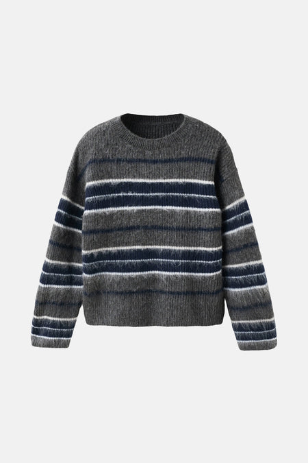 Multikleuren trui met ronde hals van MANGO, gedragen met een zwarte leren rok en bruine laarzen.