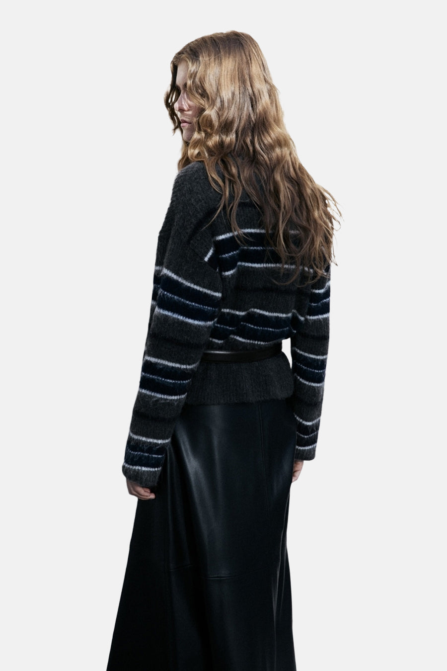 Pull à col rond multicolore de MANGO, à rayures horizontales, porté avec une jupe noire longue.
