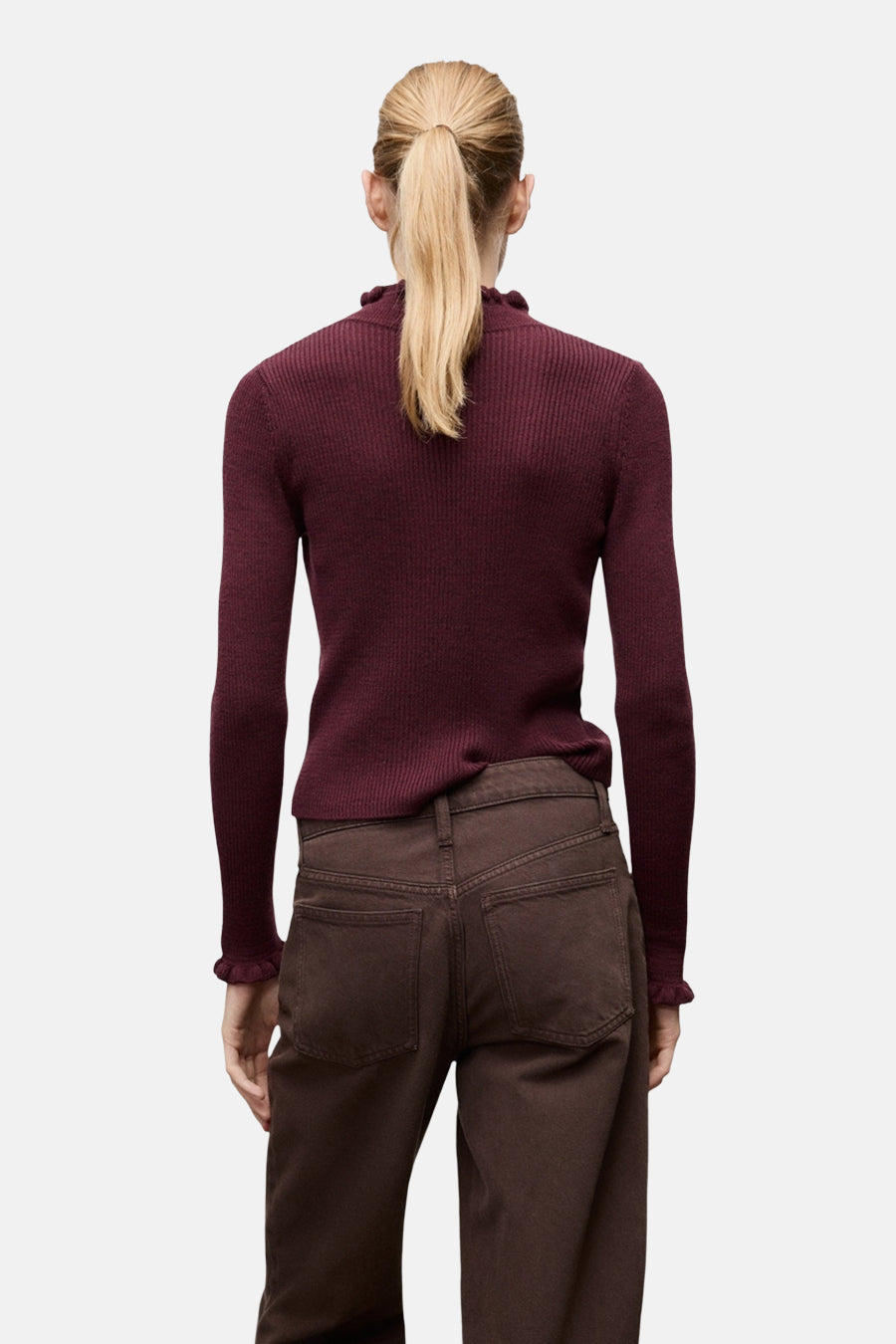 Pull bordeaux à col rond de MANGO, avec manches longues et détail volanté au col et aux poignets, porté avec un pantalon marron.