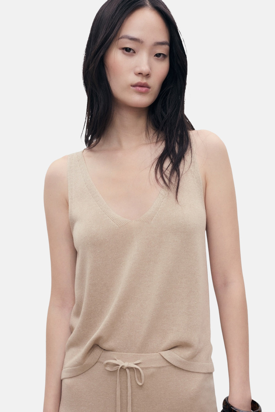 Beige tanktop van MANGO, met V-hals, op een effen achtergrond.