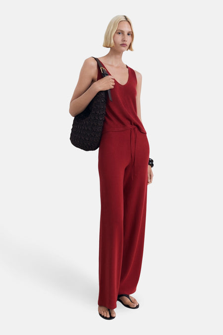 Débardeur bordeaux de MANGO, porté avec un pantalon coordonné et un sac à main en maille noire.