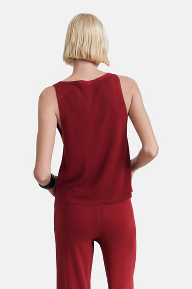 Débardeur bordeaux de MANGO, porté avec un pantalon assorti, visible de dos, avec un bracelet noir.
