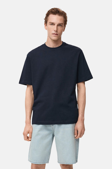 Donkerblauwe T-shirt met korte mouwen van MANGO, gedragen met een lichtblauwe spijkerbroekshort.