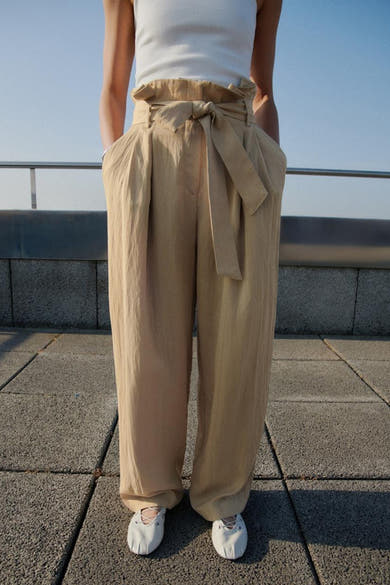 Beige broek van MANGO met strikceintuur en plooien aan de voorkant.
