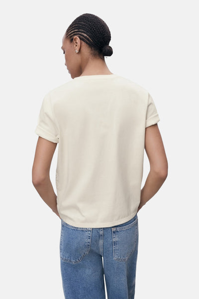 T-shirt beige à manches courtes de MANGO, porté avec un jean taille haute bleu, vue de dos.