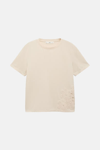 T-shirt beige à manches courtes de MANGO, avec des motifs floraux décoratifs sur le côté.
