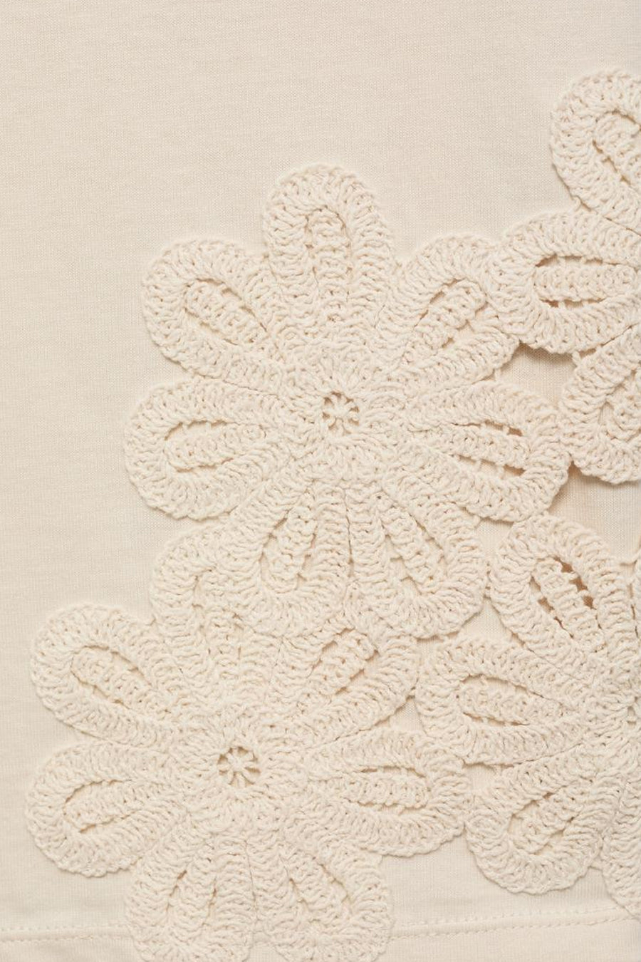 T-shirt beige à manches courtes de MANGO, avec des motifs de fleurs crochetées sur le devant.