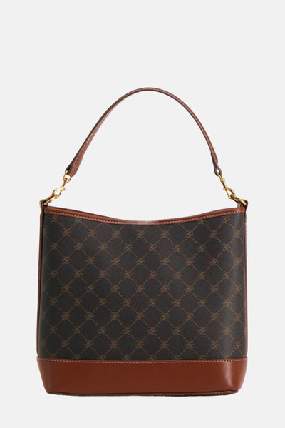 Bruine handtas van Mango, toon-op-toon monogrampatroon, met stijve handgreep en gouden details.