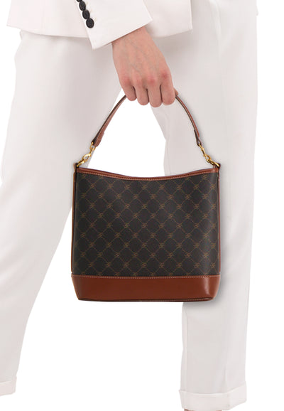 Sac à main brun par MANGO, avec motif losanges et détails en cuir marron, porté avec un tailleur blanc.
