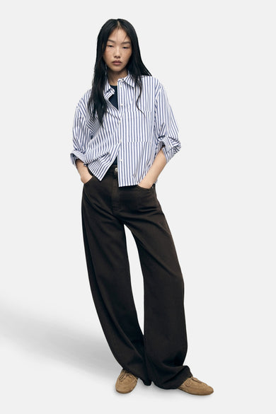 Chemisier à manches longues multicolore par MANGO, à rayures bleues et blanches, porté avec un pantalon marron ample.
