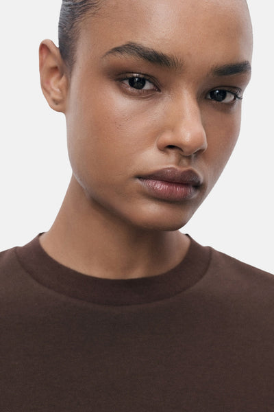 Effenchemise à manches courtes de couleur unie marron de MANGO, portée par une femme à la peau bronzée.