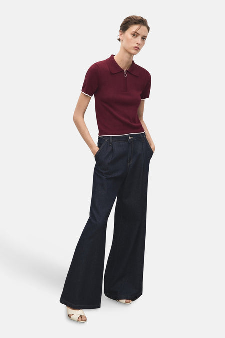 Pull à col rond bordeaux de MANGO avec fermeture éclair, porté avec un pantalon taille haute ample.